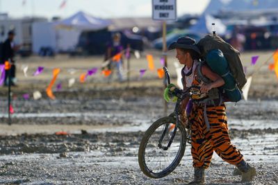 En kvinne vasser i gjørme etter regnværet som har gjort Burning Man-festivalen til en enda mer spesiell opplevelse enn normalt for de rundt 70.000 deltakerne.