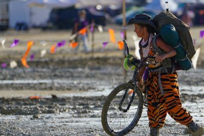 En kvinne vasser i gjørme etter regnværet som har gjort Burning Man-festivalen til en enda mer spesiell opplevelse enn normalt for de rundt 70.000 deltakerne.