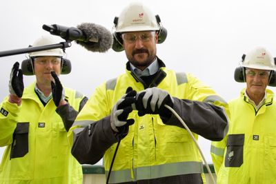 Kronprins Haakon kobler sammen to kabler for å markere den offisielle åpningen av vindparken Hywind Tampen. Bak står statsminister Jonas Gahr Støre og Equinors konserndirektør for norsk sokkel Kjetil Hove.