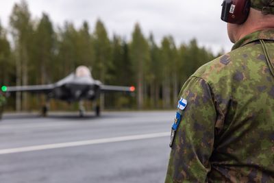 En finsk soldat foran norsk F-35A på Tervo vegbase vest for Kuopio i Finland.
