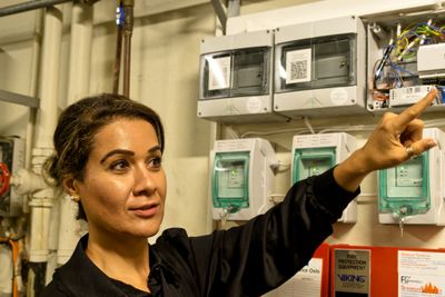 Tahani Berge i et teknisk rom på Maritimt museum, der hun installerer den fullautomatiserte kontrollen av brannslukkingsanlegget.