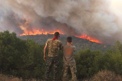 To grekere ser på flammer som sprer seg i Evros-regionen nordøst i Hellas i slutten av august. Skogbrannen her var den største som noen gang er observert i EU. 