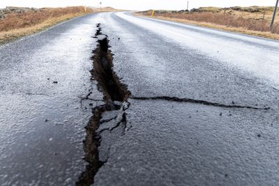 Sprekker asfalten på en vei, forårsaket av vulkansk aktivitet ved Grindavik på Island. 