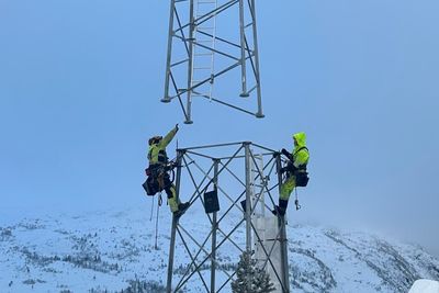 Tårnselskapets første tårn er satt opp på Flå i Hallingdal. Her tar montører fra Bjerke Nettbygg imot toppen av tårnet, som fires ned fra helikopter.