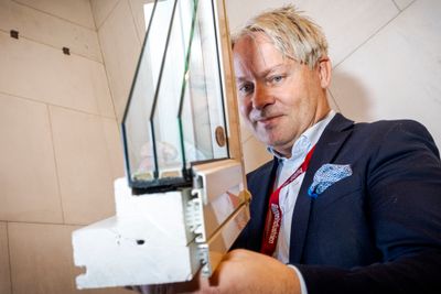 Olav Sylte med en demomodell av trelagsglasset som kan monteres i gamle, smale vinduskarmer med et klikksystem. Aluminiumsbekledning på karmen kamuflerer utstikket.