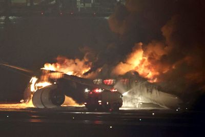 Et Japan Airlines-fly i flammer på Haneda-flyplassen i Tokyo.