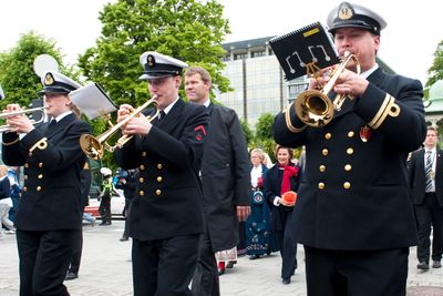 Forsvarets Musikkorps Vestlandet i sving da dronning Sonja (i bakgrunnen) skulle på den offisielle åpningen av bybanen i Bergen på Festplassen i 2010. 