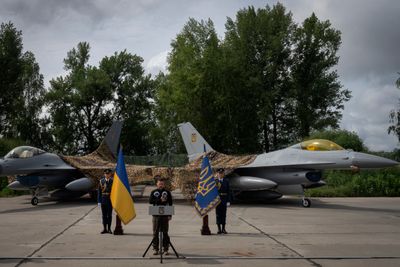 De første F-16-flyene ble levert til Ukraina denne uken. Her står Zelenskyj ved de sårt etterlengtede kampflyene på en militærbase i Ukraina søndag.