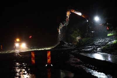 Gravemaskin jobber med å lede vann unna Østringsvegen i Gausdal nord for Lillehammer. Flere veier i området er stengt etter ras og oversvømmelser. 