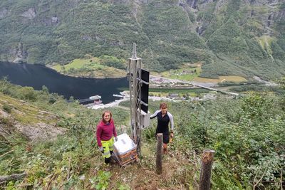 Ragnhild Lie og Torje Forstås i Cautus Geo installerer nytt utstyr i masta. Den har har solcelle og ulike kommunikasjonsløsninger som varsler hendelser, samt signalanlegg for å stenge veien.