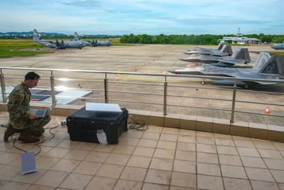 Her installerer en amerikansk soldat en Starshield-terminal på en indonesisk flystation under en øvelse i august.