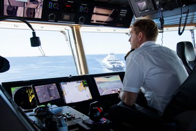 Kaptein Magnus Johansen med skjermer som viser informasjon fra radar, AIS og ECDIS – mens skjermen til høyre integrerer alt i et bearbeidet videobilde. 