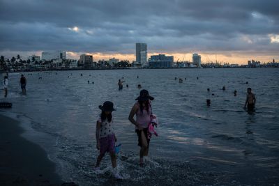 Folk kjøler seg ned i vannet under en hetebølge i Mexico i sommer.