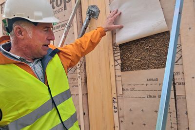 Byggeleder Fredrik Fagerberg avslører hva som skjuler seg bak vindsperreduken: 30 cm hardpakket halm.