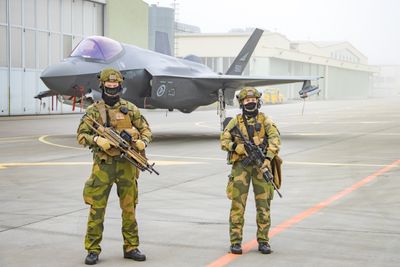 De vervede vaktsoldatene Filip og Emma passer på det norske F-35A-flyet som ble vist fram for norsk og polsk presse under den norske mediedagen ved flybasen ved Poznań i Polen i forrige uke.