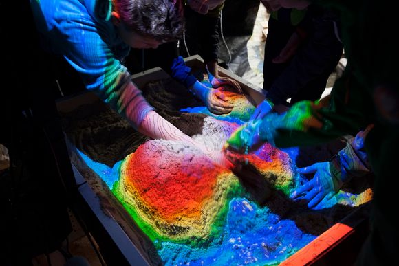 Denne sandkassen er opprinnelig laget av en geologiprofessor i USA. Han ville gjerne få flere barn til å bli interessert i geologi. Prosjektet tar i bruk Microsoft Kinect-teknologi og en prosjektor for å fargelegge