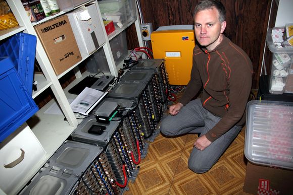 Elbil-strøm: Fra en batteritank i kjelleren hjemme i Ski kan Jon Ottar Runde følge med på strømforbruket. Den oransje boksen i bakgrunnen­ er en omformer.