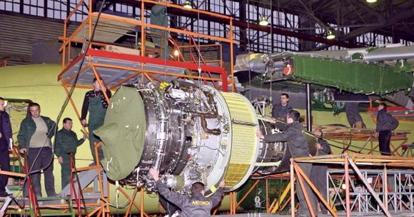 Progress D-436-motorene i ferd med å hektes under vingene på An-178-prototypen.