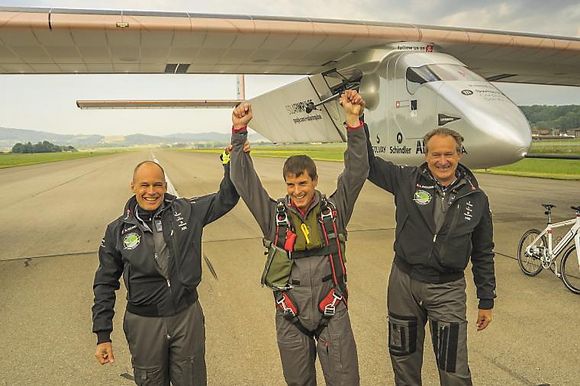 Bertrand Piccard (venstre) og André Borscberg (høyrde) gratulerer testpiloten Markus Scherdel etter vellykket jomfruferd.