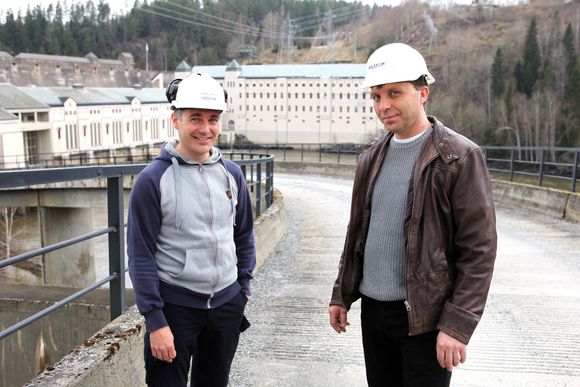 SAMARBEIDER: Prosjektleder Ronny Bråten i Hafslund (til venstre) og prosjektleder Bjørn Ove Skinstad i Alstom Vannkraft  foran elvekraftverket på Vamma, der Alstom har revidert en av generatorene.