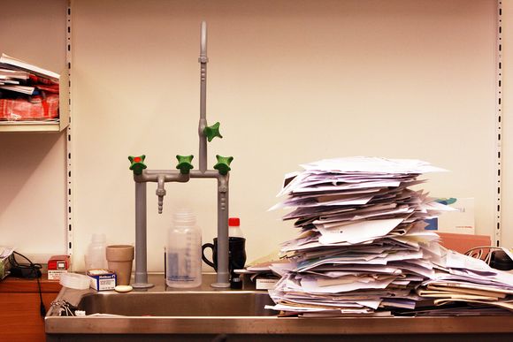 IKKE PAPIRLØS: Papirhaugene på Dag Hessens kontor er mange. Ikke en gang vasken har klart seg unna en solid stabel.