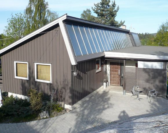 VARMEALTERNATIV: Dette er Norges første fullskala forsøkshus med solvarmeanlegg, bygget i 1977. Solfangerne helt til høyre er Aventa-teknologi med TISS-coating.