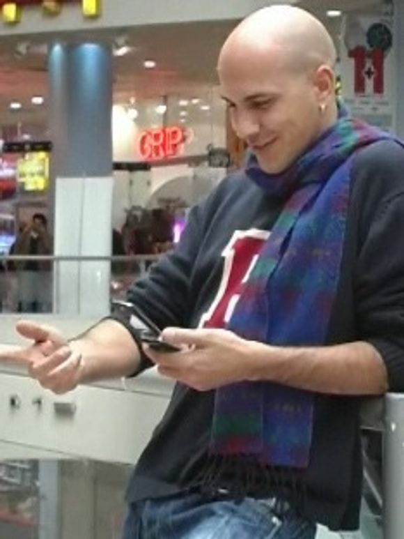 Mobilbrukeren benytter hånden foran kameraet til å styre mobilen.