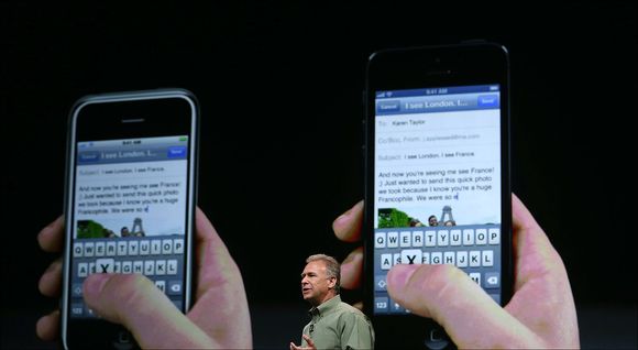 Hindret av design: På bildet presenterte Apples markedsdirektør Phill Schiller iPhone 5 (t.h). Telefonen er flaggskipet til Apple, men de klarer ikke produsere nok. Årsaken er design, mener de som setter sammen produktet. <i>Bilde: Justin Sullivan/Getty Images/All Over Press</i>