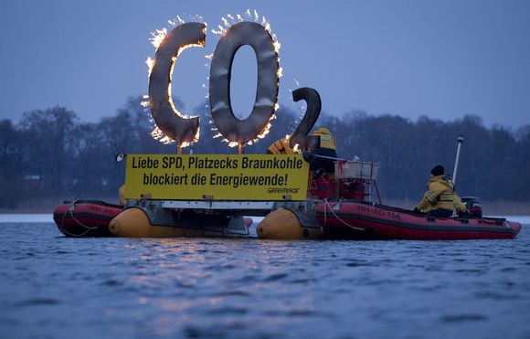Tyske Greenpeace aktivister «brenner CO2&gt;» i protest mot energipolitikken til det sosialdemokratiske partiet SPD i delstaten Brandenburg, i en elvedemonstrasjon 29. januar i år. <i>Bilde: Scanpix REUTERS/Thomas Peter</i>