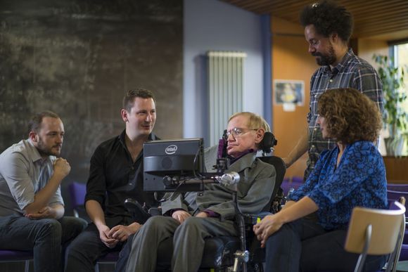 Stephen Hawking sammen med teamet som har utviklet det ny kommunikasjonssystemet han bruker. Fra venstre Steven Spencer og Joe Osbourne fra SwiftKey, Hawking, hans personlige assistent Jonathan Wood og Lama Nachman fra Intel. <i>Bilde: Intel</i>