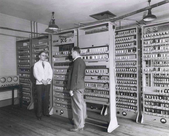 Maurice Wilkes ledet teamet som konstruerte EDSAC. Her står han foran EDSAC sammen med en forskerkollega, Bill Renwick, som også deltok i prosjektet. <i>Bilde: Computer Laboratory, University of Cambridge (CC BY 2.0)</i>