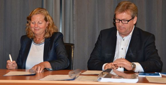 Telenors norgessjef Berit Svendsen signerer med Relacom-direktør Øystein Knudsen. <i>Bilde: Telenor</i>