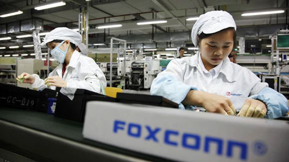 Arbeidere ved samlebåndet i en Foxconn-fabrikk i Kina som produserer iPhone. <i>Bilde: Qilai Shen/Bloomberg/Getty Images</i>