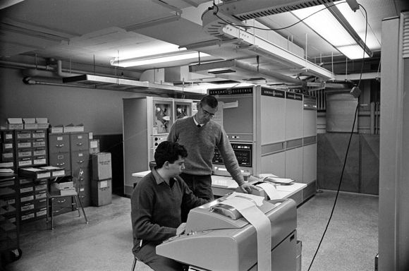 Tom Kurtz og studenten Michael Busch tester den nye GE-225-datamaskinen ved Dartmouth College i 1964. Busch var med i studentgruppen som lagde det omtalte systemet for tidsdeling av datamaskinen. <i>Bilde: Adrian N. Bouchard/Rauner Special Collections Library/Dartmouth College</i>