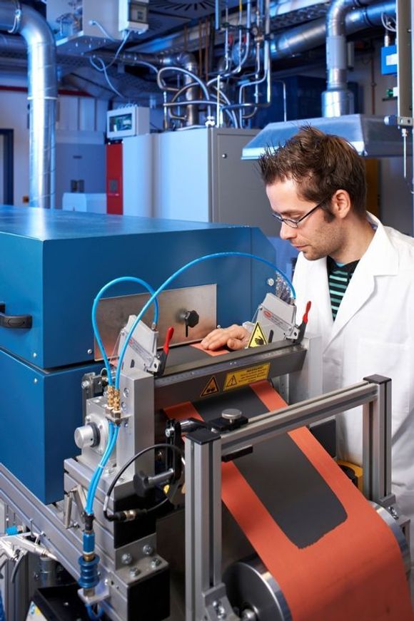 IWS-ansatt i gang med roll-to-roll-coating av elektrodene til litium-svovel-batterier. <i>Bilde: Jürgen Jeibmann / Fraunhofer IWS Dresden</i>