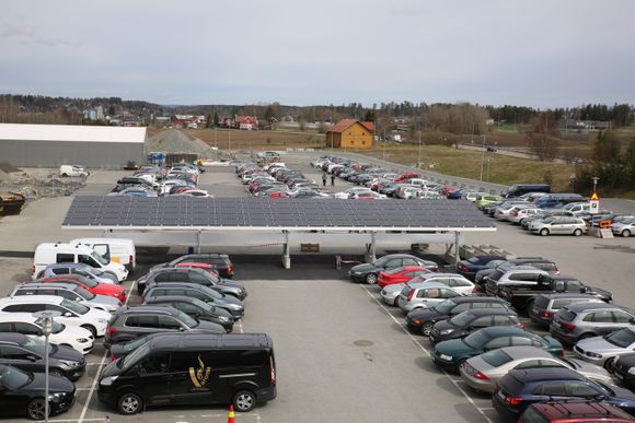 Solcellene har produsert strøm i to uker, men torsdag er første dagen ansatte kan lade elbilen mens de står parkert under de dobbeltsidige solcellene hos Asko i Vestby. <i>Foto: Jannicke Nilsen</i>
