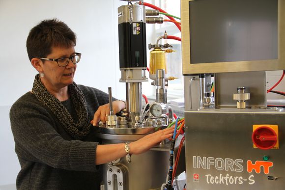 Professor Margareth Øverland ved en av de nyinnkjøpte bioreaktorene som brukes til å lage enzymer og gjær som proteinkilde. Foto: Joachim Seehusen. <i>Foto: Joachim Seehusen</i>