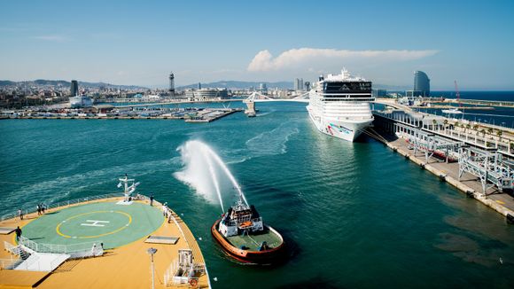 Taubåter hilser det nye cruiseskipet med å sende kaskader av vann opp i lufta ved avgang fra Barcelona. <i>Foto: Eirik Helland Urke</i>