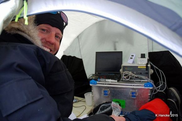 Her er Kasper Hancke (tidligere postdoc. ved Arktisk Center, og nå seniorforsker ved Norsk Institutt for Vannforskning) i gang med å måle fotosyntese i et telt ute på havisen. (Foto: Stine Højlund Pedersen)