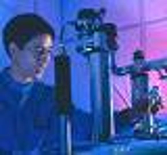 Bildet viser forsker Isaac Chuang som holder prøverøret med den 7 qubit-store kvantedata-maskinen over en kjernemagnetisk resonator. <i>Foto: IBM</i>