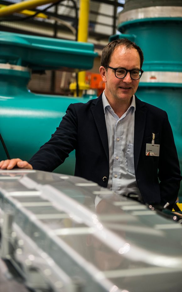 Anno Mertens, prosjektleder for ladeinfrastruktur og elektromobilitet i Audi, bak e-tron-batteriet. <i>Foto:  Mathias Klingenberg</i>