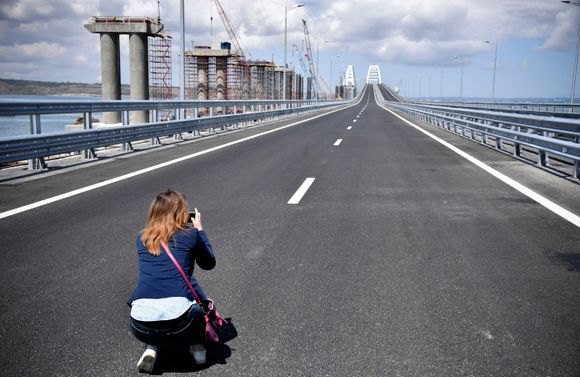 En fotograf på den nye broen som knytter Russland og Krim-halvøya sammen. <i>Foto:  Alexander Nemenov/AP/NTB scanpix</i>