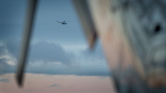 Bilde tatt fra redningsbasen på Longyearbyen denne uka. Et Mi-8 tar av og kan skimtes gjennom halerotoren på en AS332L1 Super Puma. <i>Foto:  Eirik Helland Urke</i>
