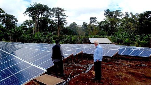 De to daglige lederne av Sunergy, Mike Fohba og Stein Skjørhammer, inspiserer det første av i alt 92 solcelleanlegg som skal forsyne kamerunske landsbyer med strøm. <i>Foto:   Sunergy</i>