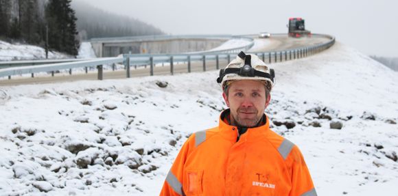Peabs anleggsarbeider Thomas Strand foran den nye brua over jernbanen på Vintermyr i Nord-Trøndelag <i>Foto:  Peab</i>