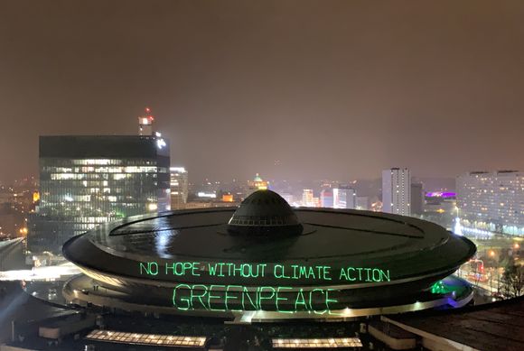 Her i Katowicei Polen finner klimaforhandlingene COP24 sted. Greenpeace-aktivister protesterte ved å projektere et slagord på taket 9. desember. <i>Foto: REUTERS/JANIS LAIZANS</i>
