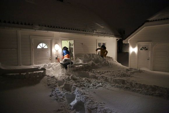 Enorme snømengder og stor snøskredfare har skapt kaos i Lofoten. Inngangsdøren hjemme hos Stein Ivar Andersen var umulig å få opp på grunn av på grunn av snømengdene, så da ble vinduene tatt i bruk av familien. Fra v. Oda Mathilde og Tobias Johan har kommet seg ut i snøen. <i>Foto:  NTB Scanpix</i>