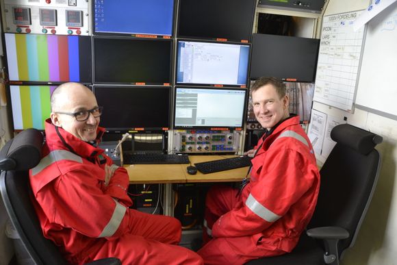 Sveiseingeniørene Neil Woodward (t.v.) og Jørund Fonneland sitter i en container på dekk om bord i overflatefartøyet og overvåker den fjernstyrte sveisemaskinens arbeide på havets bunn. <i>Foto:  Thomas Førde</i>
