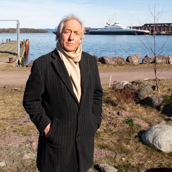 Hans Olav Tangen på stranda hvor bryggene med de flytende boligene skal ligge. «Mosseferja» i bakgrunnen. <i>Foto:  Knut Bjørheim</i>