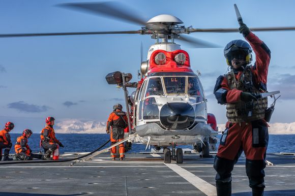 Et av Sysselmannens Super Puma-helikoptre tanker på dekket av KV Svalbard med motorene i gang. <i>Foto:  Håkon Kjøllmoen / Sjøforsvaret</i>